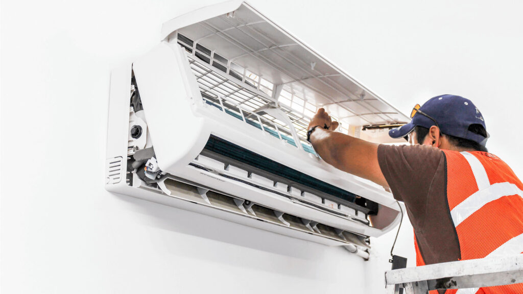 A technician is servicing the AC